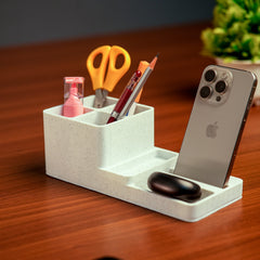 White desk organizer with phone stand, pens, scissors, and other items on a wooden surface.