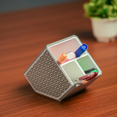 Stylish angled desk organizer with four compartments, holding colorful pens and markers, ideal for office or home workspace organization.