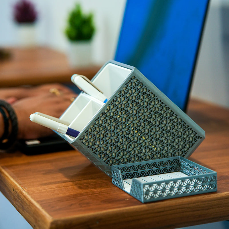 Shell-shaped organizer with stationery items on a wooden surface