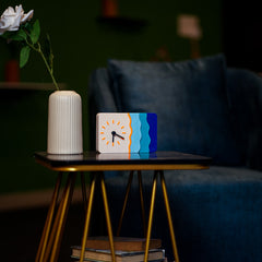 Decorative clock with colorful design on a small table in a cozy room.