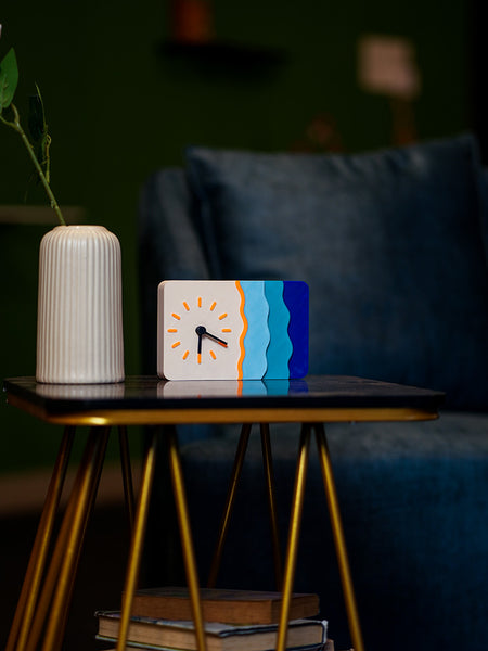 Decorative clock with colorful design on a small table in a cozy room.