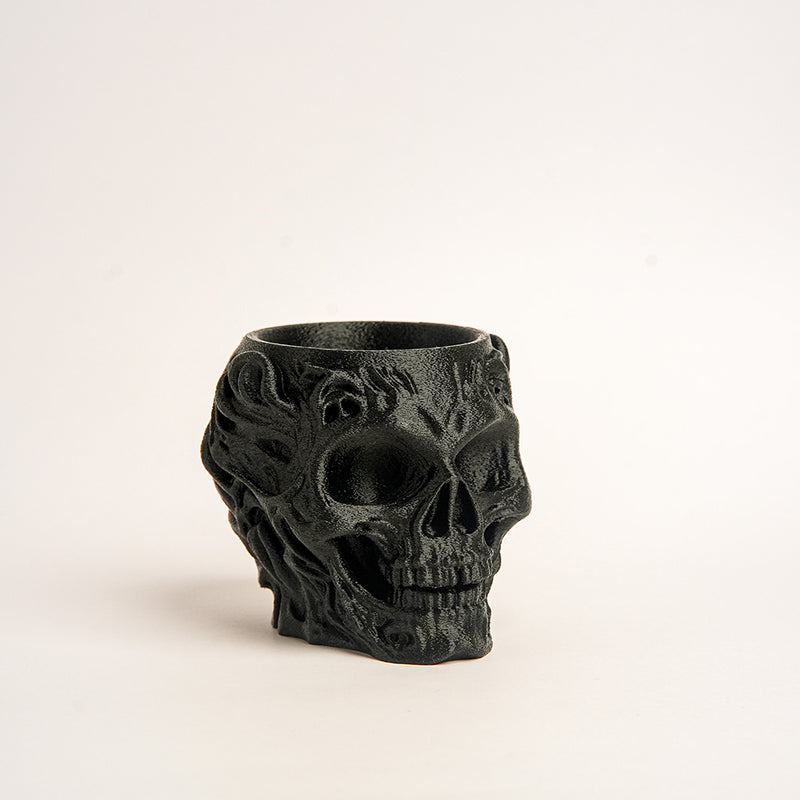 Black skull-shaped candle holder on a light beige background