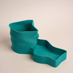 Teal textured planter with matching tray on a beige background