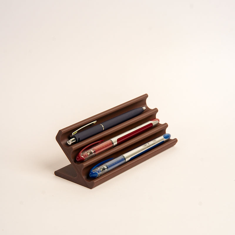 Wooden pen holder with three pens on a beige background