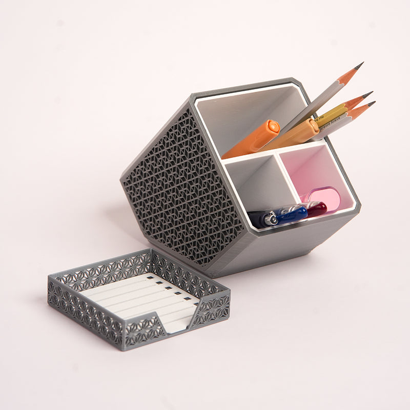 Stylish angled desk organizer with four compartments, holding colorful pens and markers, ideal for office or home workspace organization.