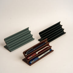 Wooden pen holder with three pens on a white background
