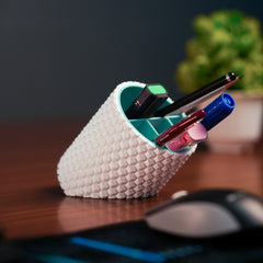 White textured pen holder with pens on a desk