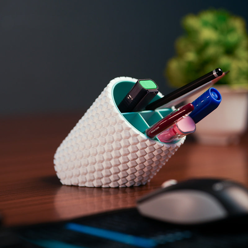 White textured pen holder with pens on a desk