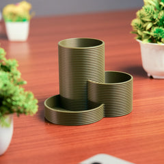Set of green ribbed planters on a wooden surface with plants in the background