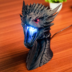 Dragon head sculpture with LED lights on a wooden surface