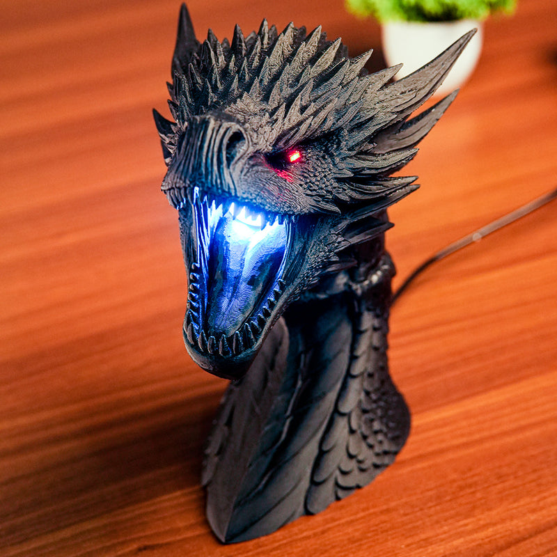 Dragon head sculpture with LED lights on a wooden surface