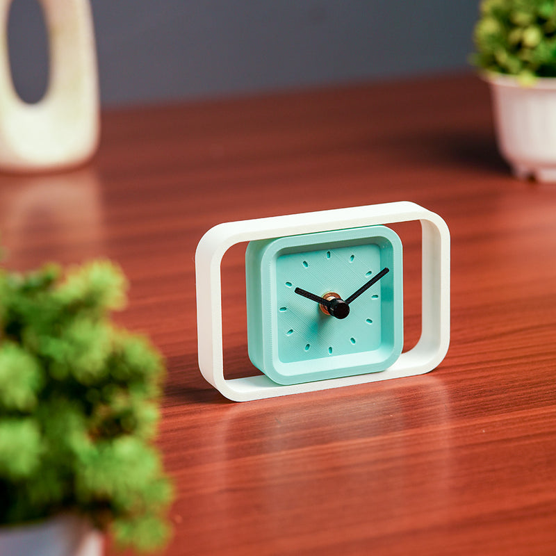 Teal clock with white frame on a wooden surface