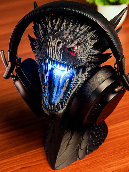 Dragon-themed gaming headset with glowing blue mouth on a wooden surface