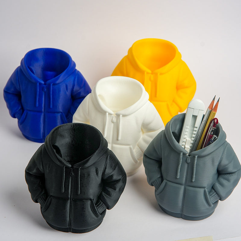 Five silicone hoodie-shaped molds in different colors with a gray mold containing pens.