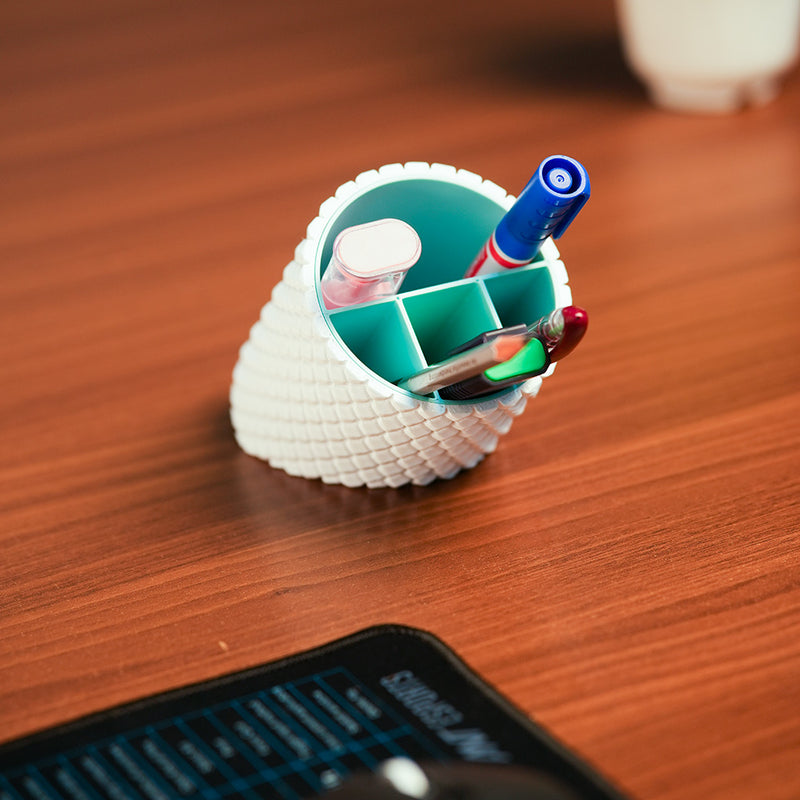 Shell-shaped organizer with stationery items on a wooden surface