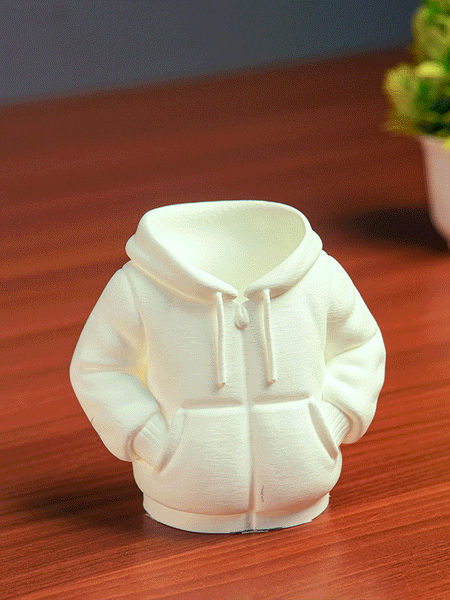 Black hoodie-shaped pen holder with stationery items on a light pink background