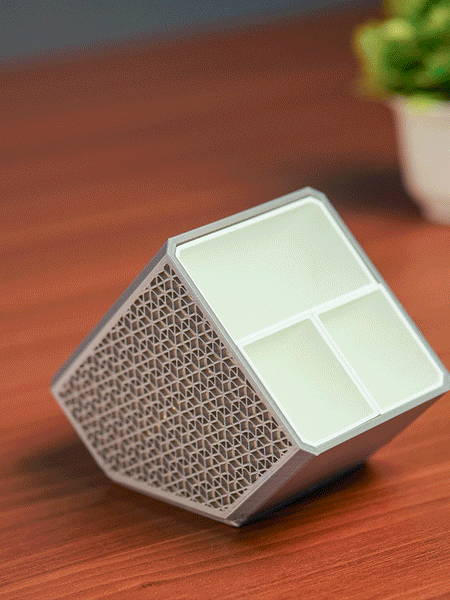 Stylish angled desk organizer with four compartments, holding colorful pens and markers, ideal for office or home workspace organization.